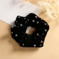 Close-up detail of black velvet hair scrunchie adorned with sparkling rhinestones. - Clover Style
