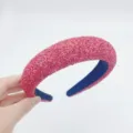 Detailed view of the pink glitter padded headband showing sparkling sequin texture and cozy fit. - Burgundy