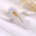 Acrylic teardrop hair clip with elegant blue marbled pattern and shiny gold clip base. - Hollow Water Drop Duckbill Clip / Aqua