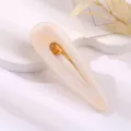 Acrylic teardrop hair clip in light marble pattern, elegant metallic duckbill clasp. - Hollow Water Drop Duckbill Clip / Light Apricot