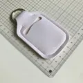 Vista detallada del llavero de neopreno blanco con regla de medición de fondo para frascos pequeños. - Blanco puro