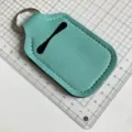 Vista detallada del soporte para botella de neopreno verde menta con llavero práctico. - Verde menta