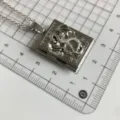 Detailansicht der silbernen Drachen Buch Medaillon Halskette mit filigranem Vintage Relief. - QX-4