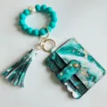 Porte-cartes portefeuille motif marbre avec bracelet en perles silicone et porte-clés pompon. - Bleu Paon