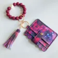 Dettaglio portachiavi da polso in silicone con porta carte galassia e nappina coordinata. - Rosso Viola Galassia