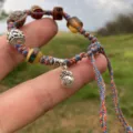 Pulsera de la suerte trenzada tibetana hecha a mano con cuentas de colores y colgante. - A-F08
