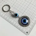 Detail view of Turkish evil eye keychain with blue glass beads and metal pendant. - Evil Eye