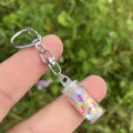 Detailansicht eines DIY Wunschflaschen Schluesselanhaengers mit bunten Sternen und Metallteilen. - bunt