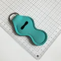Porte-clés étui à rouge à lèvres néoprène turquoise vue de détail avec anneau métal. - Bleu Paon