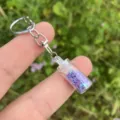 Detailansicht eines niedlichen Miniatur Schlüsselanhängers mit lila Sternen Wunschflasche. - Lila