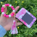 Primo piano dettagliato del portachiavi con braccialetto in perle di silicone e astuccio. - Rosso rosa