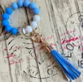 Detailaufnahme des blau-weißen Silikonperlen-Schlüsselanhänger-Armbands mit PU-Quaste. - Saphirblau
