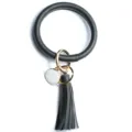 Dettaglio in primo piano del portachiavi bracciale in pelle PU nera con nappa e anelli metallici. - Blu navy