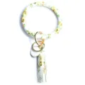 Detail view of the yellow floral printed PU leather circle keychain with matching tassel and rings. - White Yellow Floral
