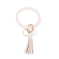 Close-up van beige PU lederen O-ring sleutelhanger met gouden ring en kwastje detail. - Beige