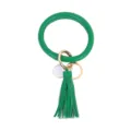 Detailopname van groene PU lederen cirkel sleutelhanger met kwastje en gouden ring. - Grasgroen
