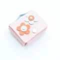 Gros plan détaillé du joli porte-monnaie en cuir rose avec décor de fleurs pour écouteurs. - Rose