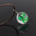 Transparent glass sphere necklace featuring a natural green four leaf clover specimen pendant. - Four-Leaf Clover / Brown Chain