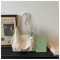 Sac bandoulière hobo chic blanc cassé avec zips avant et joli pendentif en peluche. - Beige avec Pendentif