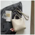 Beige textured leather bucket bag with top handle and strap for women daily commuting. - Beige Without Pendant