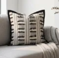 Close-up detail of the black and white woven throw pillow with black velvet border and tassels. - Tassel Grid Wide Edge 45x45