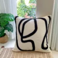 Detail shot of decorative throw pillow with abstract black tufted lines on beige fabric for sofa. - Chenille Thoughts 45x45