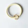 Detailweergave van de ronde PU lederen polsband sleutelhanger met gouden metalen ring. - Broken Wit