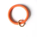 Nahaufnahme des leuchtend orangen PU-Leder runden Armband-Schlüsselanhängers mit goldenem Ring. - Orange