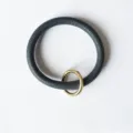 Nahaufnahme Detail des dunkelblauen PU-Leder Armband Schlüsselanhängers mit Goldring. - Marineblau