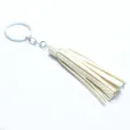 Detailed shot of white leather tassel keychain, metallic ring and chain accessory pendant. - Beige Style