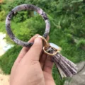 Vista di dettaglio del portachiavi a braccialetto rotondo in ecopelle serpente con nappa. - Serpente Argentato Rosa
