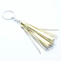 Gold white leather tassel keychain detail shot, premium bag accessory pendant close-up. - Gold Color