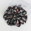 Vista dettagliata dell'elastico per capelli in raso floreale marrone, morbido ed elegante. - Caffè