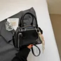 Μαύρη τσάντα χειρός PU σε σχήμα κοχυλιού με μεταλλικά φερμουάρ και κομψό μενταγιόν. - Με Κρεμαστό / Μαύρο