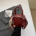 Dark red patent leather handbag, stylish shell crossbody bag with unique white stitching. - With Pendant / Red