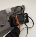 Black patent leather mini crossbody bag with chic chain strap and orange rope charm. - With Pendant / Black