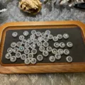 Dettaglio di perline distanziali artigianali fai-da-te con cabochon in pietra naturale rotonda. - Scatola Chiaro di Luna Grigio
