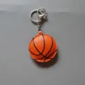 Detailed view of the basketball keychain showing textured leather and sturdy metal keyring. - Basketball
