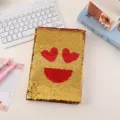 Close-up of a sparkling sequin notebook with heart eyes emoji design on white desk. - Red Heart Smiley Face