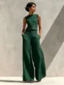 Detail view of the elegant sleeveless top and wide-leg pants set in green with red stitching. - Green