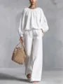 Elegantes weißes Set mit Laternenärmeln und weiten Hosen, detaillierte Studio-Modelpräsentation. - Weiß