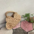 Detailaufnahme der handgehäkelten Strohtasche mit 3D-Blumenmustern in sanftem Beigeton. - Khaki