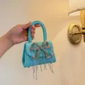 Detailaufnahme einer hellblauen geprägten Handtasche mit funkelnder Kristallschleife. - Himmelblau