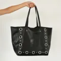 Detailed view of a black metal grommet tote bag, large capacity shoulder bag, casual style. - Black (Large)