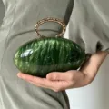 Französische marmorierte ovale Clutch mit kaltem Metallringgriff und edler grüner Marmoroptik. - Grün