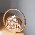 Elegant rose gold metallic camellia embossed spherical handbag with round ring handle. - Rose Gold