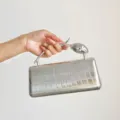 Nahaufnahme Detail der silbernen Metallic Krokodilmuster Abendtasche mit speziellem Metallgriff. - S / Silber
