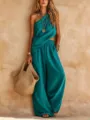 Stylish teal one-shoulder top and wide-leg pants set detail, paired with a woven straw bag. - Malachite green