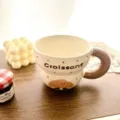 Detailed close-up of a cute ceramic coffee mug featuring croissant graphic and brown handle. - 300ml / Croissant