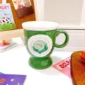 Green ceramic coffee mug with lily of the valley pattern and footed base for home office use. - 320ml / Green Lily Of The Valley